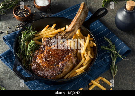 Les steaks cuits Tomahawk nourri à l'herbe avec des frites et de romarin Banque D'Images