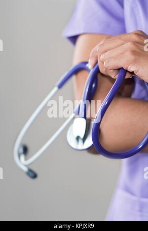 Female doctor holding stethoscope, bras croisés. Banque D'Images