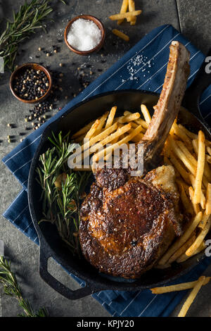 Les steaks cuits Tomahawk nourri à l'herbe avec des frites et de romarin Banque D'Images