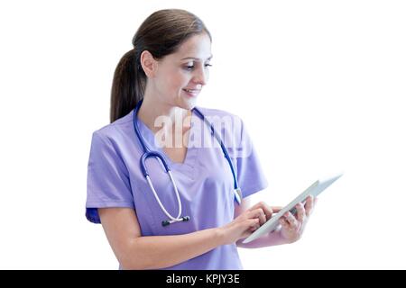 Nurse wearing uniformes violet using digital tablet. Banque D'Images