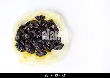 Les prunes séchées dans un sac sur fond blanc Banque D'Images