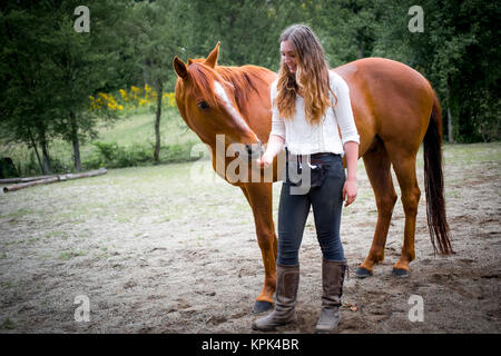 Une adolescente pour nourrir et prendre soin de son cheval ; British Columbia, Canada Banque D'Images