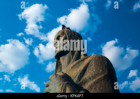 Un pigeon se repose sur la tête d'un évangéliste sculpture de bronze à l'extérieur de la cathédrale de Brasilia, Brasilia, Brésil Banque D'Images