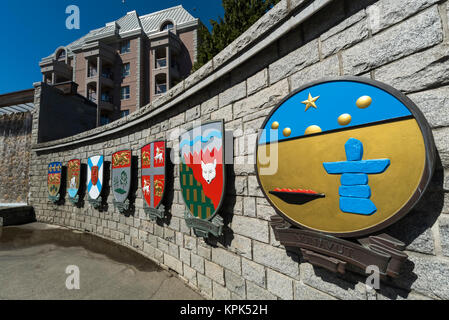 Emblèmes symboliques colorées et de dessins sur un mur de pierre le long d'une allée piétonnière représentant les provinces canadiennes ; Victoria, British Columbia, Canada Banque D'Images