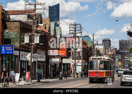 Le tramway, commerces et les piétons le long d'une rue ; Toronto, Ontario, Canada Banque D'Images