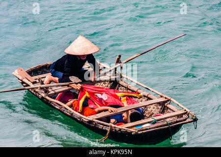 Une Vietnamienne avec deux enfants le bateau d'aviron à Ha Long Bay Banque D'Images