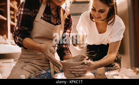 Femme potter enseignement de l'art de faire de pot. Les femmes qui travaillent sur des objets en argile de potier. Banque D'Images