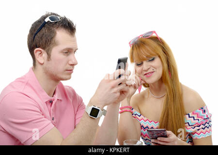 Jeune couple d'envoyer des messages texte sur leurs téléphones. Banque D'Images