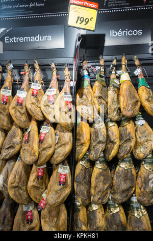 Jambon Ibérique séché entier de raccrocher dans un supermarché Espagnol Banque D'Images