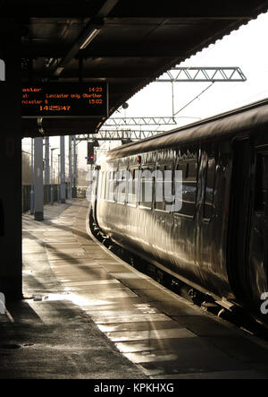 À la recherche de Sun sur le côté d'une classe 156 diesel train à la plate-forme 1 dans Carnforth station avec un Carlisle à Lancaster service. Banque D'Images