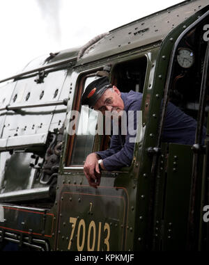 Le pilote de conserves de British Railways Standard Class 7 locomotive à vapeur no. 70013 Oliver Cromwell incliné vers l'extérieur de sa fenêtre de la cabine. Banque D'Images