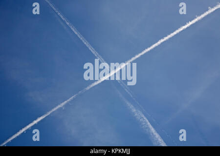 Des traînées de vapeur d'aéronefs ou de traînées à travers un ciel bleu, formant une croix de saint André. Banque D'Images