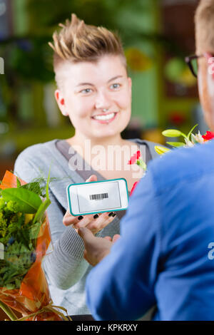 Boutique de fleurs jeune client en utilisant Coupon électronique Banque D'Images