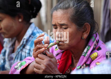 Une vieille femme de Birmanie fumant des cigares Banque D'Images