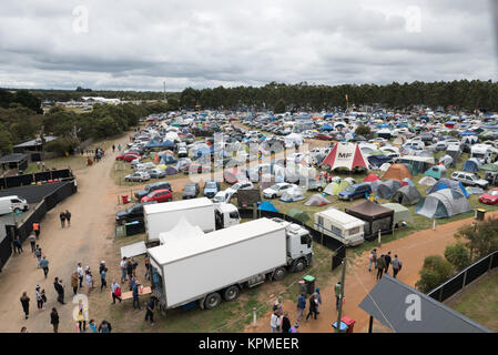 Vue aérienne de très grand festival de musique de camping contenant des tentes, caravanes, voitures et forêt en distance. Banque D'Images