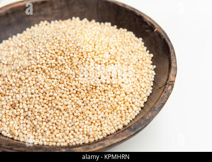 Les graines de quinoa en soufflé bol en bois rustique isolé sur fond blanc Banque D'Images