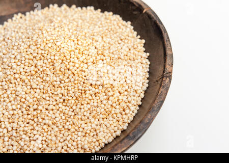 Les graines de quinoa en soufflé bol en bois rustique isolé sur fond blanc Banque D'Images