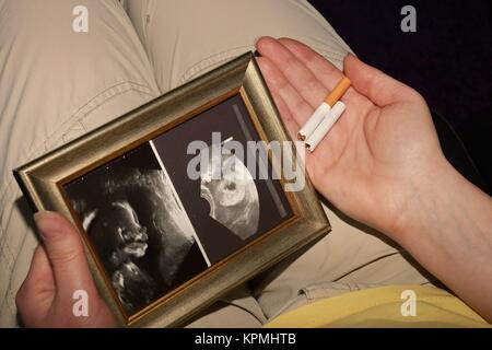 femme enceinte avec une image échographique et une cigarette cassée Banque D'Images