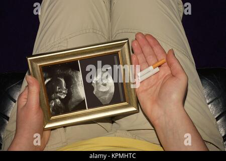 femme enceinte avec une image échographique et une cigarette cassée Banque D'Images