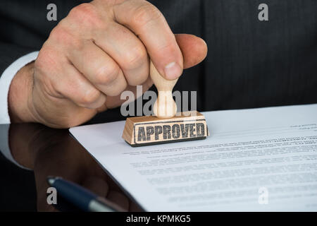 Close-up of Businessman Hand piétinement sur le formulaire de contrat approuvé Banque D'Images