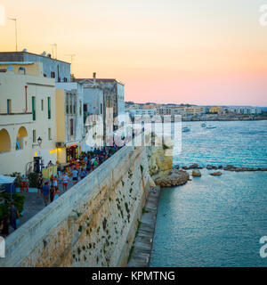 Au pic de la saison touristique, la foule de touristes est la marche au coucher du soleil sur la route de la nouvelle à la vieille ville de Otranto Banque D'Images