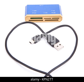 Lecteur de cartes externe USB et câble USB est repliée en forme de cœur sur un fond blanc Banque D'Images
