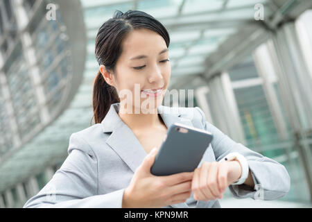 Femme d'affaires connexion smart watch et le téléphone mobile Banque D'Images