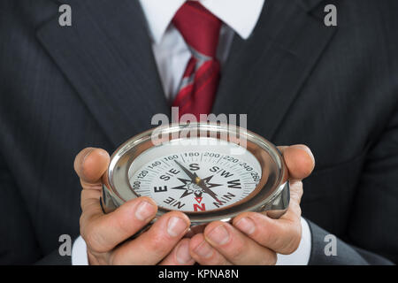 Close-up of Businessman Holding Compass Banque D'Images