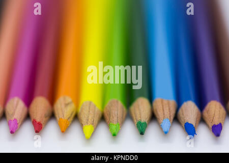 Crayons de couleur organisé dans une ligne sur un fond blanc Banque D'Images
