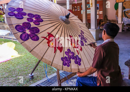 Chiang Mai, Thaïlande - 25 décembre 2013 : l'homme peint des fleurs sur parapluie dans Chiang Mai, Thaïlande Banque D'Images