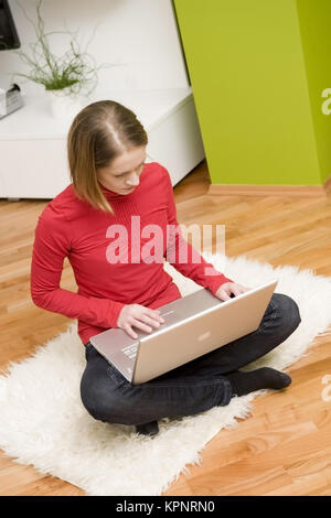 Modèle libération , Junge Frau sitzt mit Laptop in 1-2 - young woman with laptop Banque D'Images