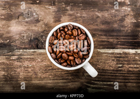 Kaffeebohnen in einer Tasse auf Holz untergrund Banque D'Images