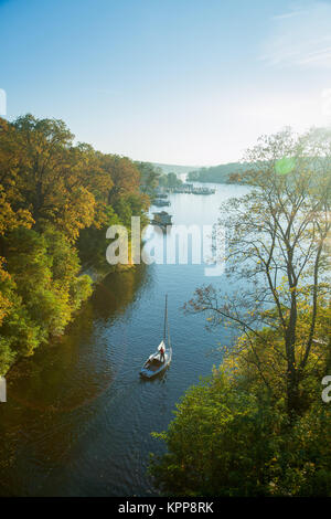 Bateau à voile solitaire sur une rivière en automne Banque D'Images