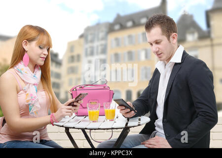 Couple heureux avec téléphones portables dans un café terrasse Banque D'Images