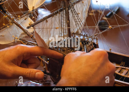 Jeune homme construisant un modèle de navire dans un studio de modélisation de navire Banque D'Images