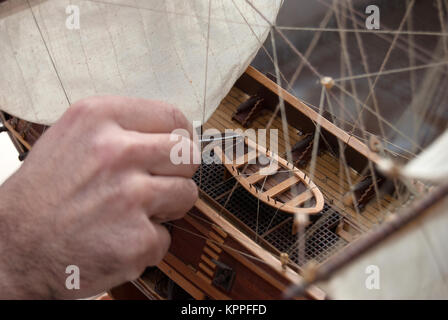 Jeune homme construisant un modèle de navire dans un studio de modélisation de navire Banque D'Images