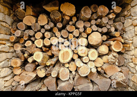 Une pile de grumes pour bois de chauffage hachées stockées dans woodshed Banque D'Images