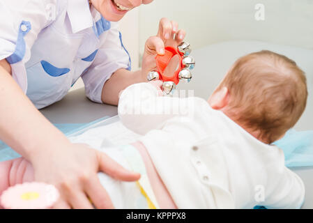 Close up médecin avec nouveau-né dans une clinique pédiatrique moderne. Moteur de l'enfant l'éducation. Focus sélectif. Un espace réservé au texte Banque D'Images