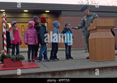 Le Colonel Ryan Samuelson, 92e Escadre de ravitaillement en vol, Michael Anderson accueille les élèves du primaire à la scène d'appeler pour le Père Noël, pendant la cérémonie d'arbre de vacances 1 Décembre, 2017, à Fairchild Air Force Base, à Washington. Les enfants ayant des parents déployés ont été invités à rejoindre Samuelson sur scène pour accueillir le Père Noël à la chapelle de la base à la lumière de l'arbre. (U.S. Air Force Banque D'Images