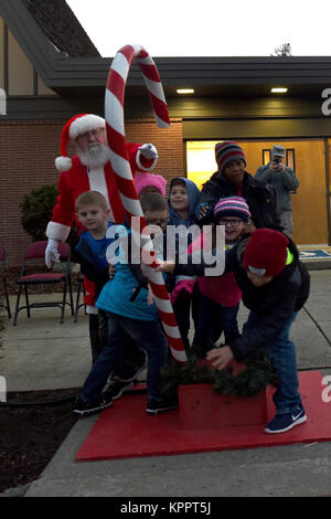 Le Colonel Ryan Samuelson, 92e Escadre de ravitaillement en vol, Michael Anderson accueille les élèves du primaire à la scène d'appeler pour le Père Noël, pendant la cérémonie d'arbre de vacances 1 Décembre, 2017, à Fairchild Air Force Base, à Washington. Les enfants ayant des parents déployés ont été invités à rejoindre Samuelson sur scène pour accueillir le Père Noël à la chapelle de la base à la lumière de l'arbre. (U.S. Air Force Banque D'Images