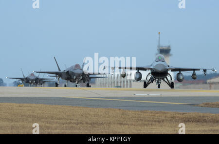 Un U.S. Air Force F-16 Fighting Falcon et quatre F-35A Lightning II affecté à la 34e Escadron de chasse expéditionnaire Hill Air Force Base, Utah, taxi vers la fin de la piste au cours de l'exercice VIGILANT ACE 18, le 3 décembre 2017, à Kunsan Air Base, République de Corée. Les aviateurs du 34e à l'EFS Kadena Air Base, Japon en octobre, et envoyé des avions et des aviateurs à participer à la semaine d'exercice annuel ACE vigilante à l'appui du Traité de défense mutuelle entre les États-Unis et la République de Corée. (U.S. Air Force Banque D'Images