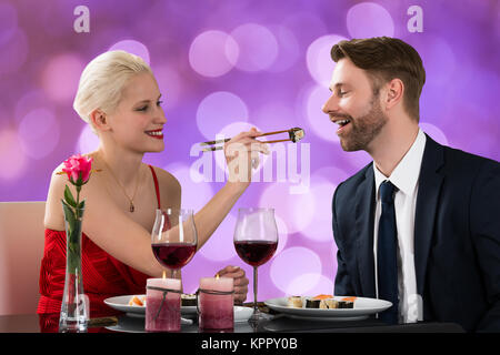 Woman feeding Man at Restaurant Table Banque D'Images