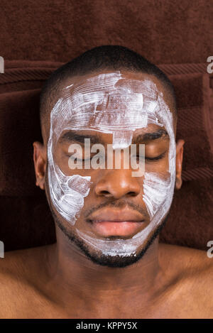 Masque de visage appliqué au jeune homme Banque D'Images