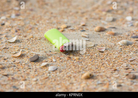 Ancien briquet utilisé dans le sable sur la plage Banque D'Images