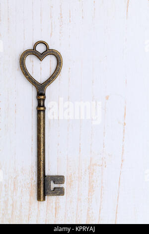 Forme de coeur clé vintage sur fond de bois blanc Banque D'Images