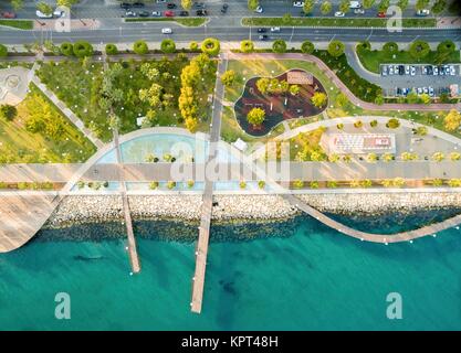 Vue aérienne de Molos, Promenade sur la côte de Limassol à Chypre. Une vue de la promenade chemin entouré de palmiers, des piscines d'eau, herbe, promenade, la mer Méditerranée, des jetées, des rochers et paysage urbain. Banque D'Images