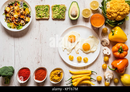 Des aliments sains pour le petit déjeuner. Oeufs frits, sandwiches, avocat végétalien salade de légumes, carotte jus frais et colorés différents légumes et épices biologiques Banque D'Images