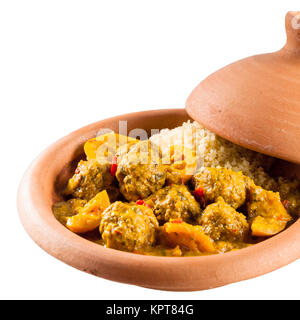 Close Up Still Life View of Traditional Berbère Tajine plat fait avec des boulettes de viande, couscous et Salé sauce curry servi dans la Poterie argile couvert plat sur fond blanc avec copie Espace Banque D'Images