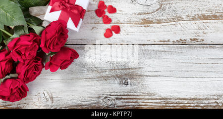 Boîte-cadeau avec des roses rouges et coeurs en bois rustique en vue mise à plat Banque D'Images