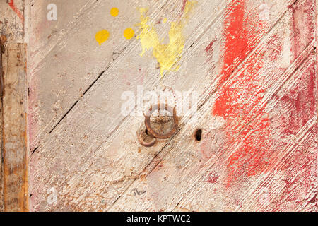 Vieille porte en bois peint multicolore avec boucle de métal rouillé. Banque D'Images